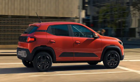 Dacia Spring electric car driving outdoors, showing compact city car design